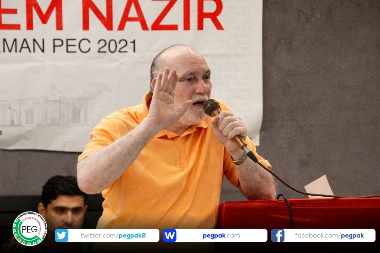 Engr. Waseem Nazir speaking into a microphone at a gathering of engineers in Dera Ghazi Khan.