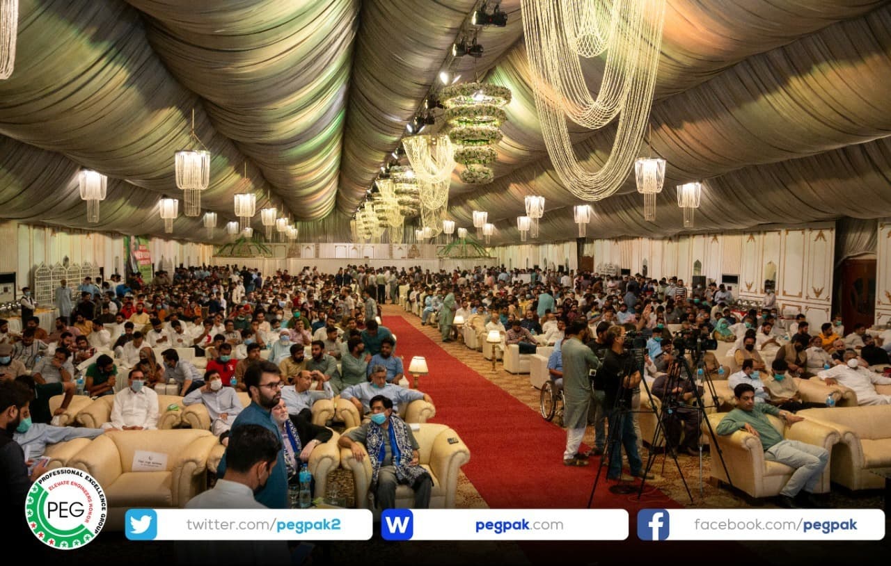 A large decorated hall filled with engineers seated at tables at the Multan power show.